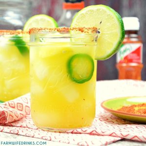 Spicy Pineapple Margaritas are an easy pineapple jalapeno margarita made with silver tequila, triple sec, pineapple and lime juices, and jalapenos with Tajin seasoning rimmed glass.