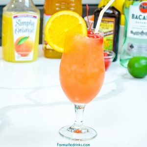 The New Orleans Hurricane Drink can be made at home with light and dark rum, passion fruit juice, orange juice, and grenadine. Top it off with a simple orange slice and maraschino cherries.