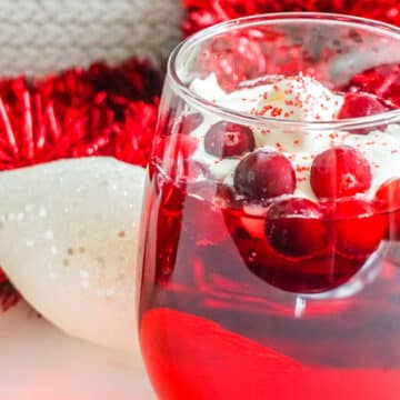 Christmas Punch Topped with whipped cream and Frozen Cranberries.