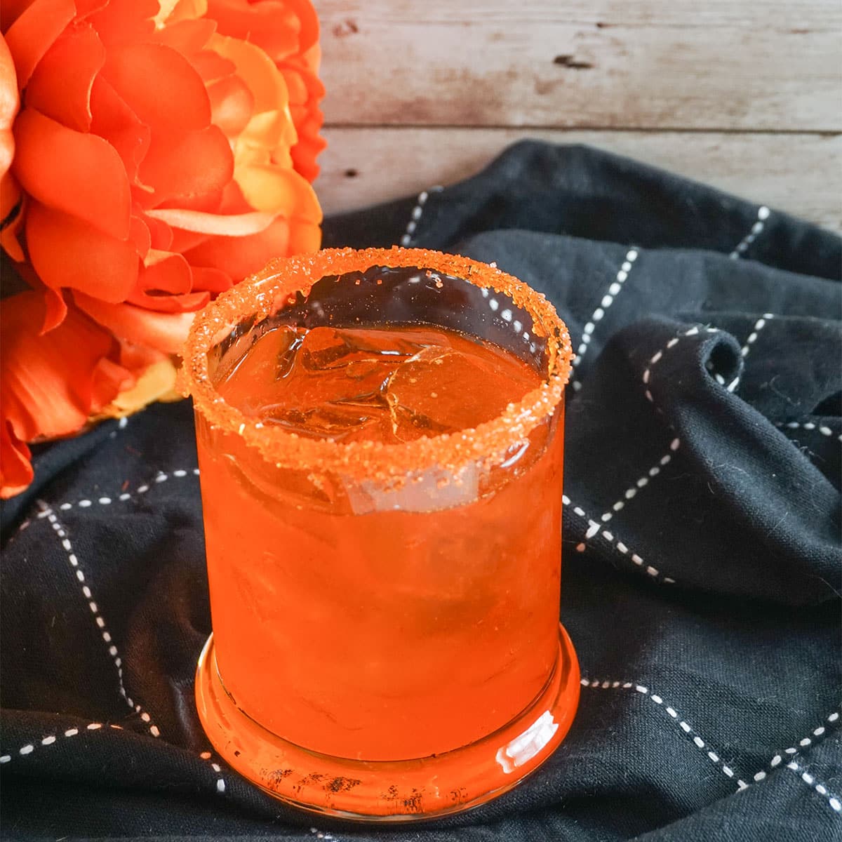 Sitting on top of a dish towel with matching in color flowers, Orange Crush Cocktail.