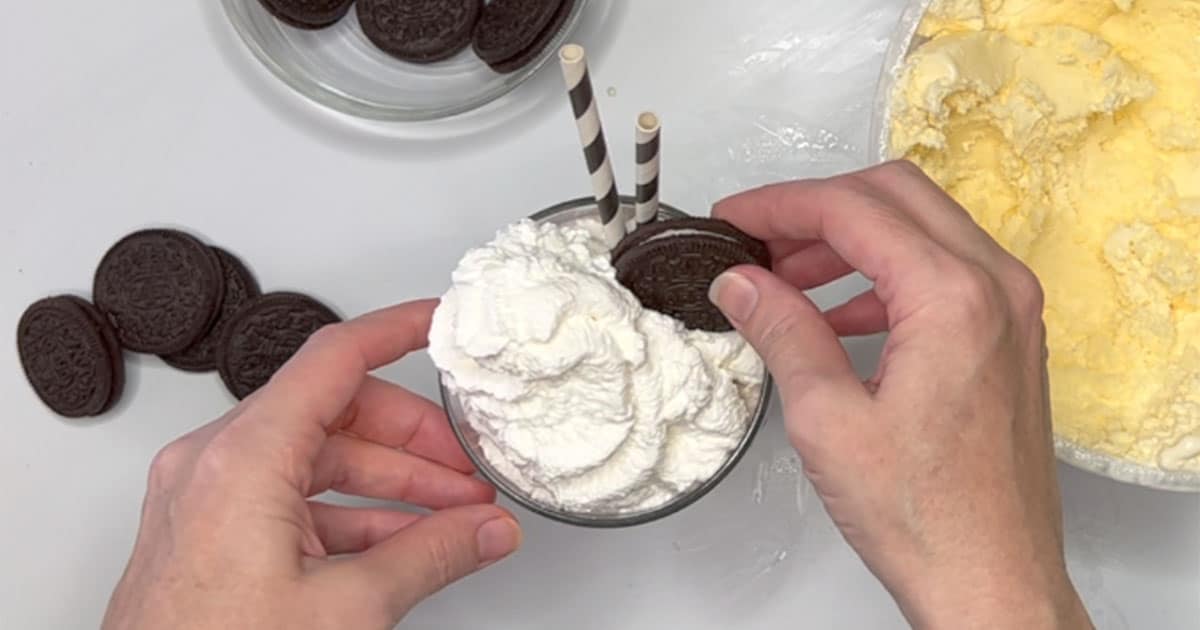 Topping Oreo Milkshake with Whipped topping and Oreo cookie.