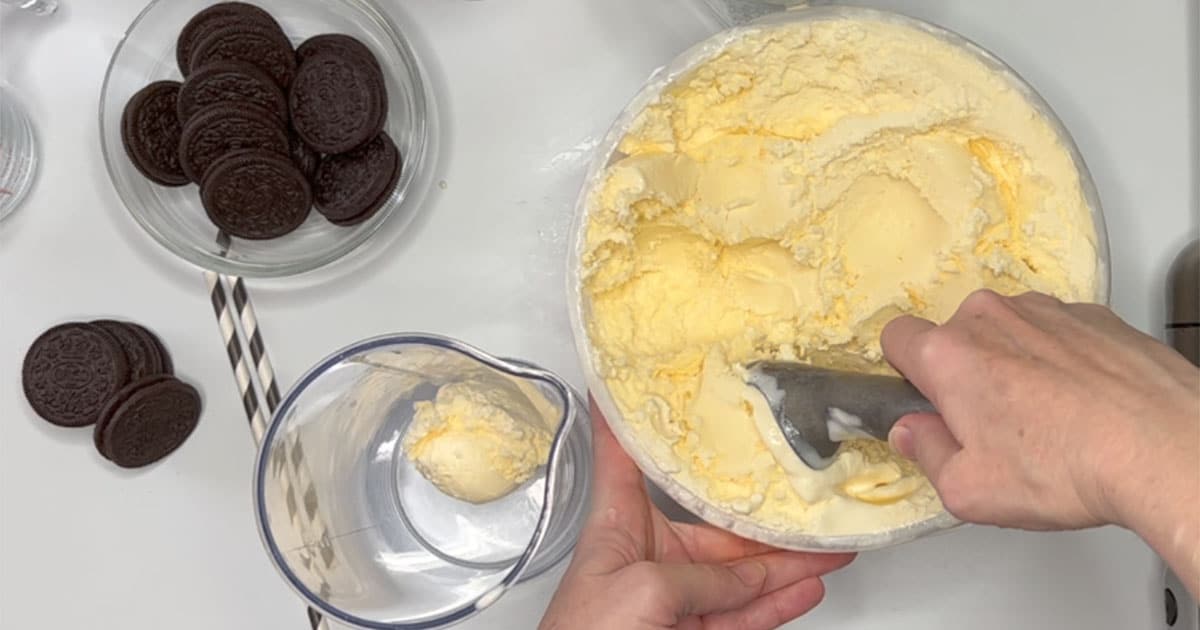 Scooping vanilla ice cream into immersion cup for Oreo Milkshake.