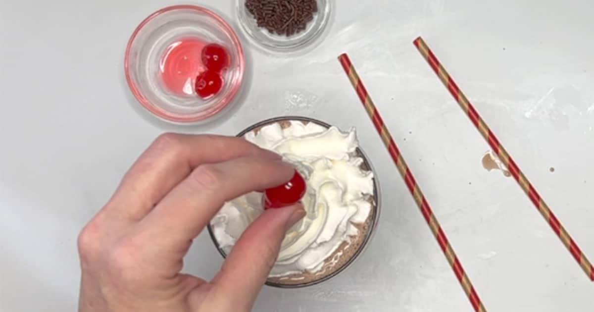 Adding cherries to Chocolate Milkshake.