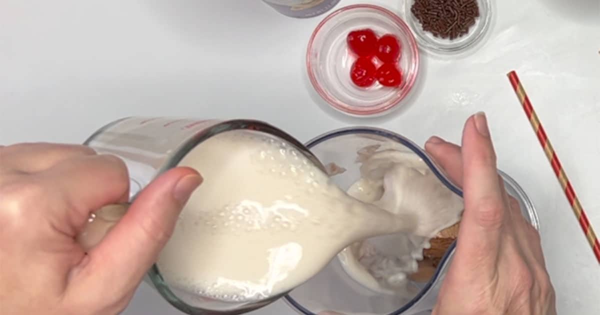 Adding milk to chocolate ice cream for Chocolate Milkshake.