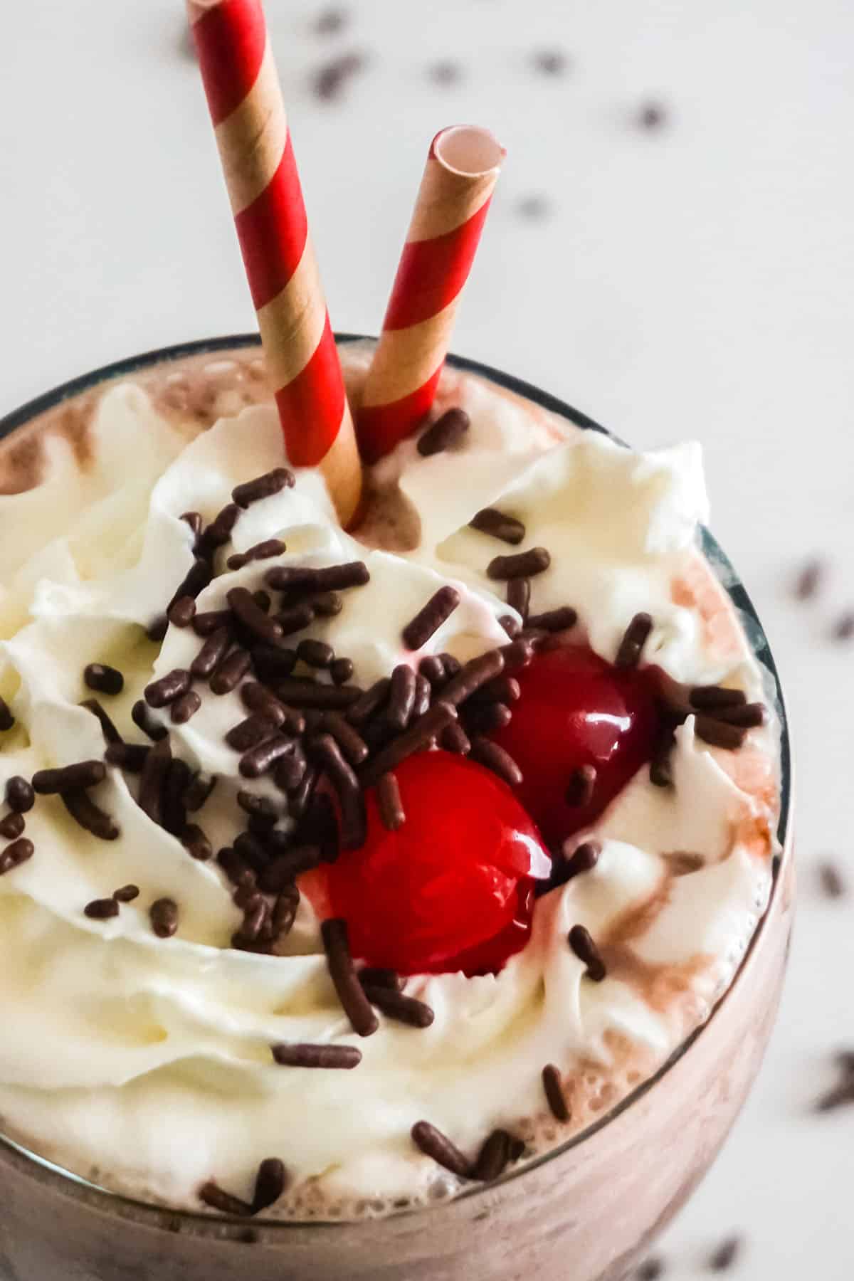 Top close up, of Chocolate Milkshake with cherries.
