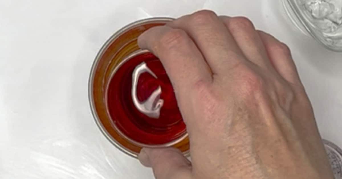shot being dropped into a glass of red bull to make a Vegas Bomb Cocktail